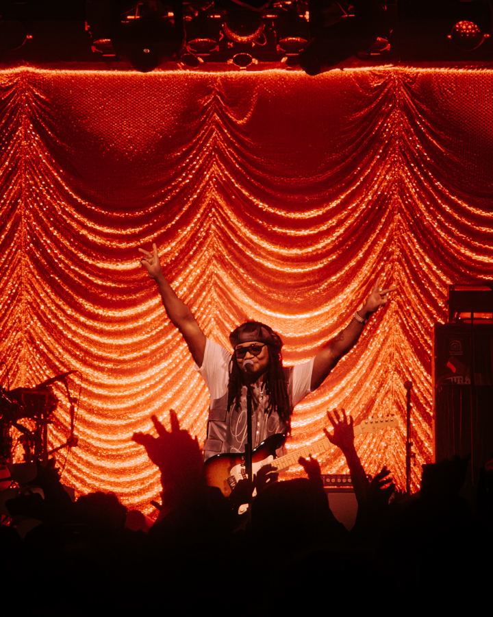 Arms up against the red curtain